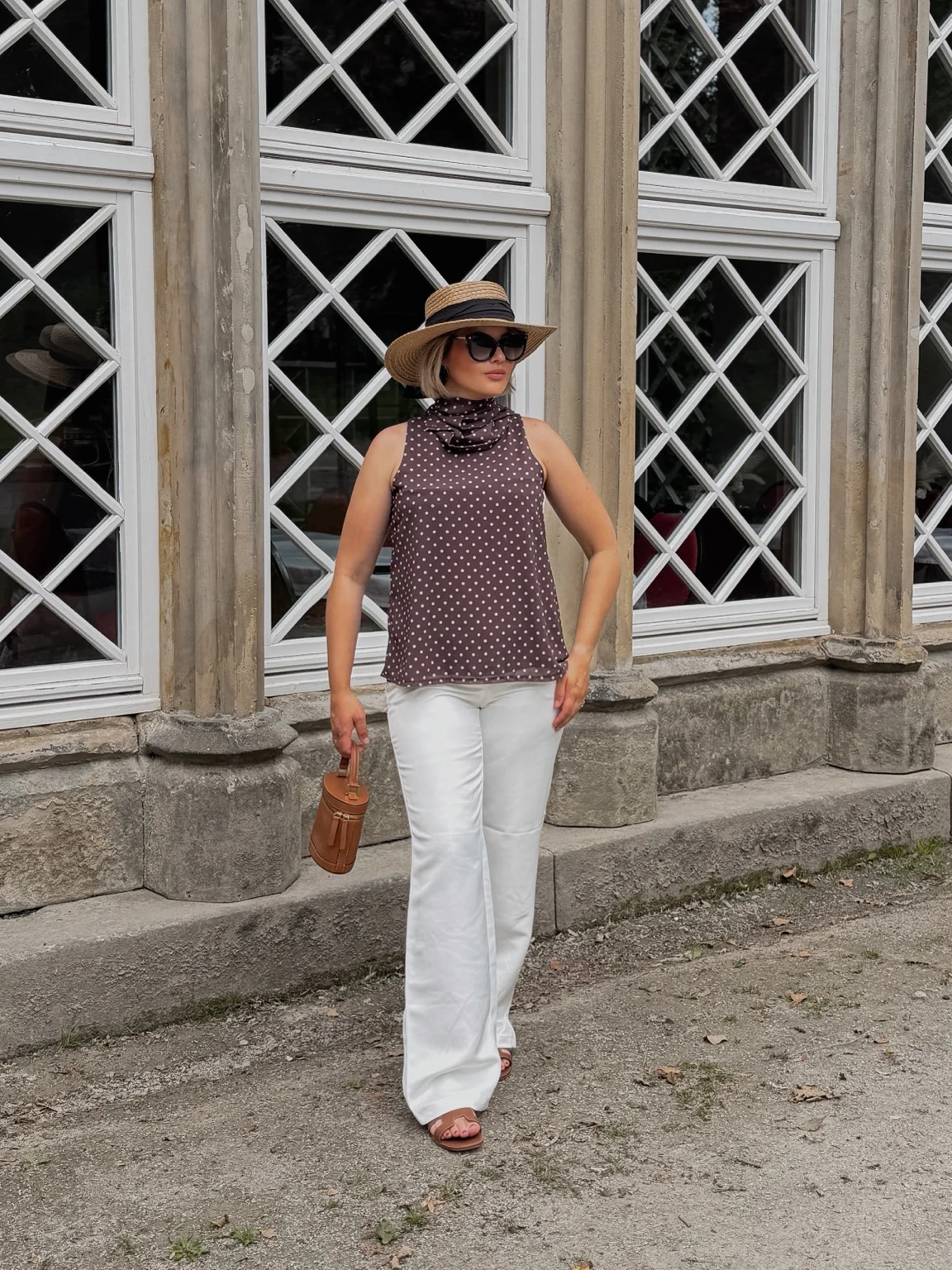 Lara in a summer outfit beside a window